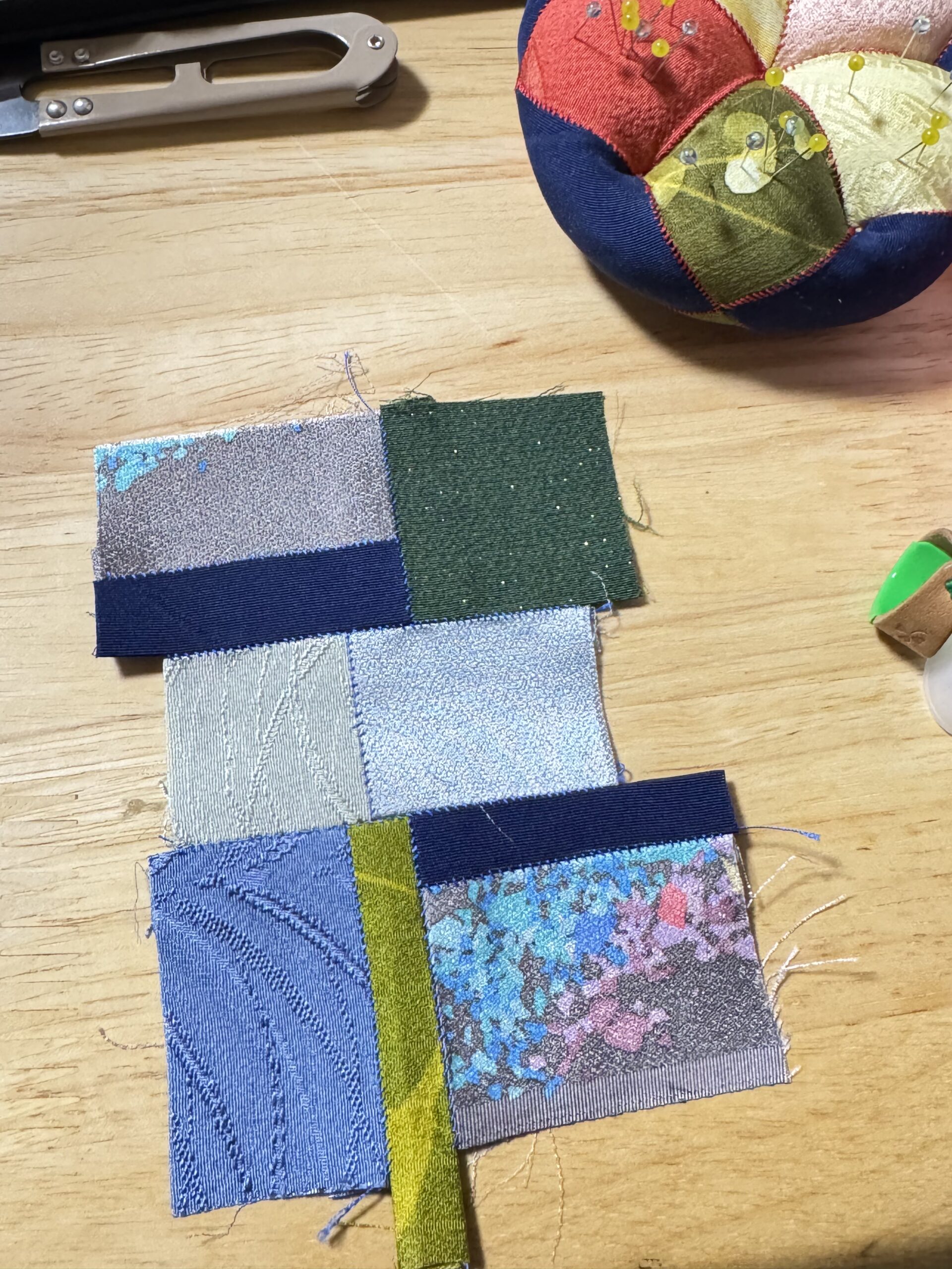 青や緑など色とりどりの四角い絹布を縫い合わせた、シルペ制作途中の布